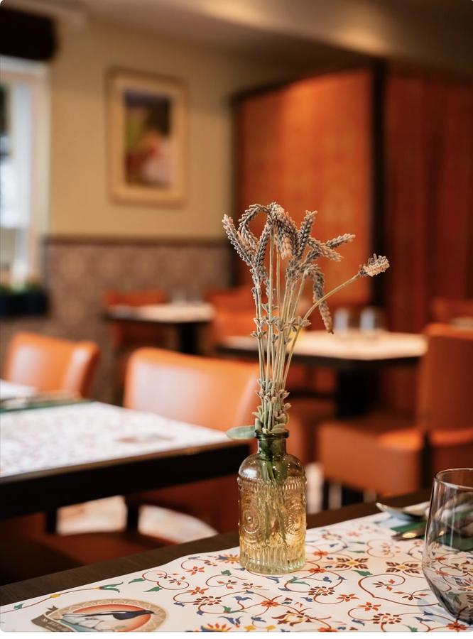 Salle du restaurant, table dressée avec bouquet séché